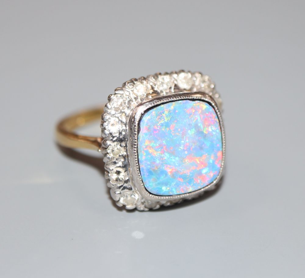 An 18ct, black opal doublet and diamond cluster set dress ring, size N, gross 6.8 grams.